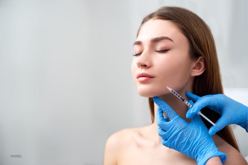 Young women getting a dermal filler injection with her cosmetic surgeon.